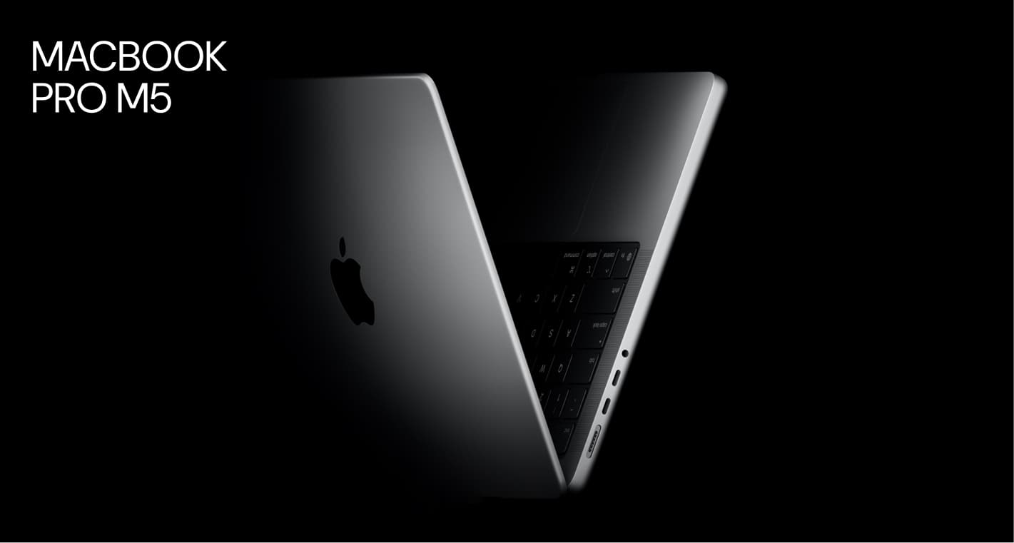 MacBook Pro M5 partially open, displaying slim, sleek design, illuminated keyboard, and visible ports on a black background.