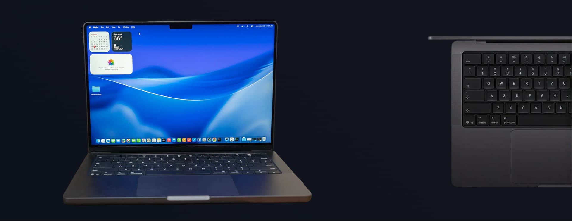 Open laptop with blue wavy screen and app icons, next to a partial view of a laptop keyboard on a dark background.